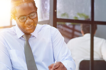 Wall Mural - a man at a workplace at a table in front of a computer writes down notes