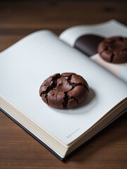 Poster - A Glossy Magazine Page Showcases A Single Dark Double Chocolate Cookie Sitting Alone On A Simple Wooden Table Top.