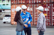 © DJ Creative Studio - Industrial worker discussing cargo logistics with a colleague at a busy container yard. International shipping and global trade concept.