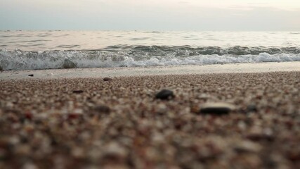 Poster - Soft waves roll onto a sandy beach as twilight sets in. Calm sea reflects the fading light, creating a serene atmosphere for evening relaxation. Reflection of yellow rays. Mediterranean Adriatic Sea