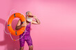 © deagreez - Photo of serious focused life guard man look empty space with orange lifebelt wear dotted swimsuit isolated pastel color background