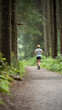 © Kanchanit - happy jogger running on scenic forest trail surrounded by trees and greenery, enjoying fresh air and nature