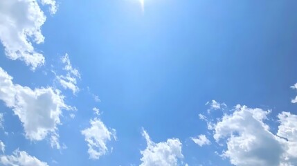 a light blue sky dotted with fluffy cumulus clouds, creating a cheerful and open atmosphere on a per