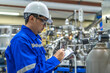 © reewungjunerr - Asian engineer working at Operating hall,Thailand people wear helmet  work,He worked with diligence and patience,she checked the valve regulator at the hydrogen tank.