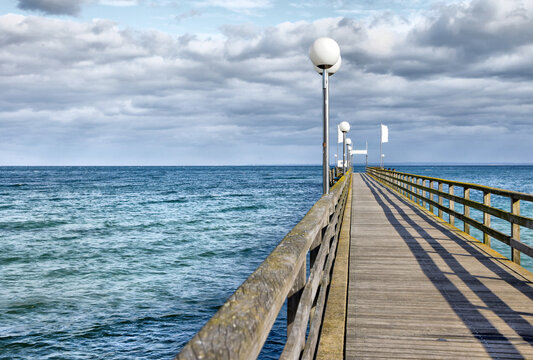 A pier with a wooden walkway and a pier light