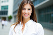 © Minerva Studio - Businesswoman smiling in front of office buildings
