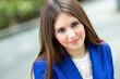 © Minerva Studio - Young businesswoman smiling and posing outdoors, wearing a blue blazer