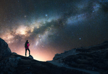 Wall Mural - glowing milky way and woman on mountain peak at starry night. dolomites, italy. galaxy. space landsc