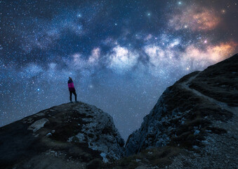 Wall Mural - glowing milky way and woman on mountain peak at starry night. dolomites, italy. galaxy. space landsc