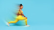 © Prostock-studio - Workout Training. African American fitness lady stretching legs lunging forward, wearing yellow fitwear over blue studio background, embodying strength and wellness.