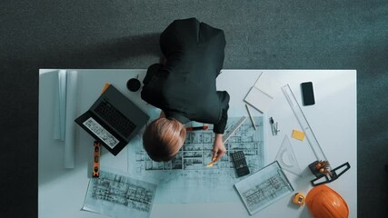 Poster - top view of manager using ruler to measure project plan while looking at building construction on la
