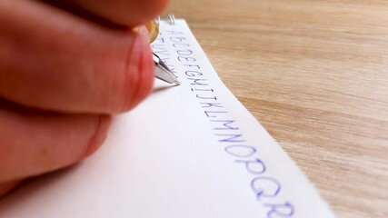 Fototapete - Girl writes the English alphabet on a notebook with a pen. The letters of the English alphabet, learning English.