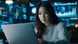 © Futureaz - Young Asian woman analyzing data on laptop at desk.
