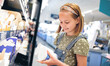 © Ievgen Skrypko - Pretty girl child choosing yogurt in supermarket shop. Beautiful female preteen kid looking milk products in grocery store
