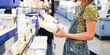 © Ievgen Skrypko - Pretty girl child choosing milk bottle in supermarket shop. Beautiful female preteen kid looking lactose latte products in grocery store