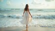 © IgorImageDoc - young woman walking beach she wearing long white dress flowing wind woman has long blonde hair facing away camera ocean visible background small waves crashing onto shore sky blue white clouds