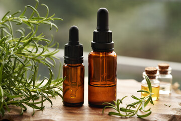 Wall Mural - Bottles of rosemary essential oil on a table