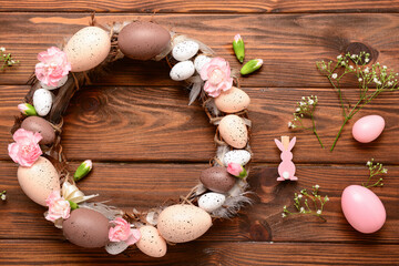 Canvas Print - Easter wreath decorated with eggs and flowers on wooden background. Top view