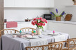 © Pixel-Shot - Dining table set for Easter with eggs and tulips in kitchen