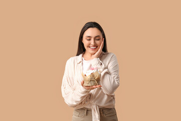 Canvas Print - Beautiful young woman with sweet Easter cake on brown background