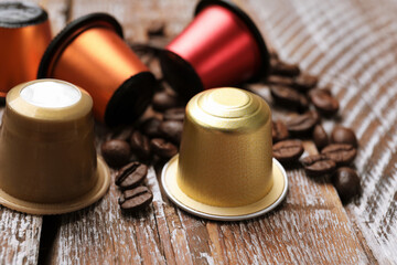 Wall Mural - Coffee capsules and beans on wooden table, closeup