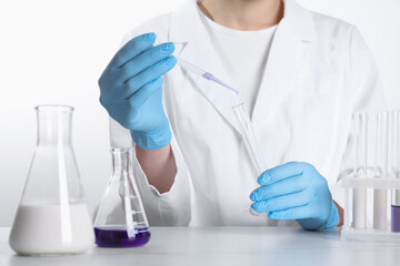 Wall Mural - Laboratory testing. Scientist working with glassware at white marble table, closeup