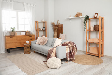 Wall Mural - Shelving units, pouf and grey sofa near white wall in interior of living room