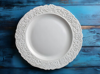 Wall Mural - Elegant white decorative plate set against a blue wooden background evoking rustic charm and culinary creativity perfect for food presentations