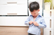 © yAOinLoVE - A 4-year-old Asian kindergarten boy focuses on buttoning his shirt by himself in the dressing room at home. Childhood independence, self-care skills, and early development, Soft and selective focus