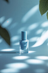 Poster - elegant blue nail polish bottle surrounded by soft shadows and green leaves in a bright indoor setti