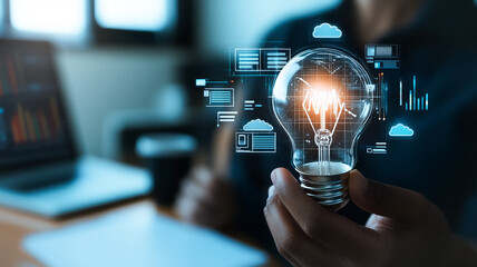 Poster - Illuminating Ideas: An individual grasps a glowing lightbulb, symbolizing innovation and creativity with data visualization elements, in a setting implying modern technology and business. 