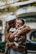 © qunica.com - A couple shares a warm embrace outdoors, enjoying a crisp autumn day. The scene exudes love, warmth, and contentment, capturing a perfect moment of happiness and connection in a natural setting.