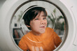 © VISTA by Westend61 - Child fooling around in front of a washing machine at home