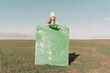 © VISTA by Westend61 - Young woman holding green painting on dry field