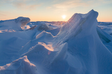 Wall Mural - view of large ice hummocks and snowdrifts. winter arctic landscape. sunrise over the frozen sea. col