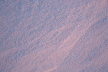 Wall Mural - beautiful winter background with snowy ground. natural snow texture. wind sculpted patterns on snow 