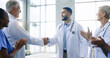 © peopleimages.com - Healthcare, applause and handshake by doctors in a hospital with partnership, success or deal. Thank you, shaking hands and medical team excited for clinic promotion, congratulations or achievement