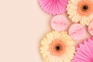 Wall Mural - gerbera flowers, tissue paper fans and balls on a beige background. place for text.