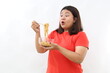 © ArvStd - Ecstatic and surprised Asian woman holding a bowl of fried instant noodles.