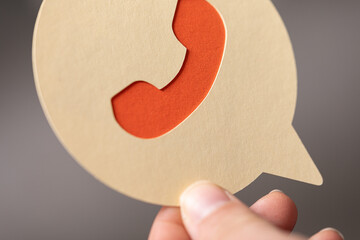 Poster - Hand holding speech bubble with cutout phone icon.  Perfect for customer service, support, or communication concepts.