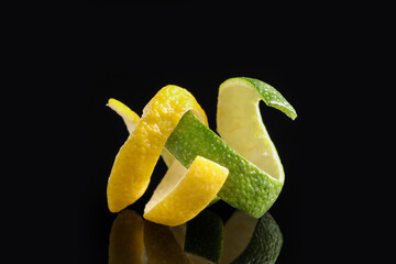 Wall Mural - Lemon and lime peels on black glass surface, closeup