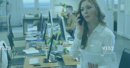 Poster - image of data processing over caucasian businesswoman talking on smartphone in office
