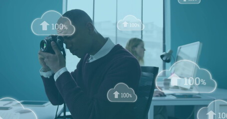 Poster - Image of clouds with growing numbers over african american businessman working in office