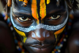 Portrait of african tribesman with face painting, head adornment and colourful necklaces