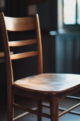 Poster - A simple wooden chair sits in front of a window, perfect for a home office or reading nook
