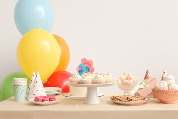 Canvas Print - Table with different sweets and balloons for birthday party against white wall