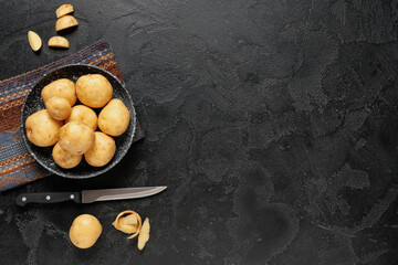 Poster - Bowl with raw potatoes on black background