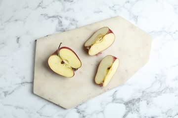 Poster - Cutting board and cut apples on white marble table, top view