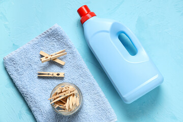 Wall Mural - Jar of wooden clothespins with laundry detergent and clean towel on grunge blue background