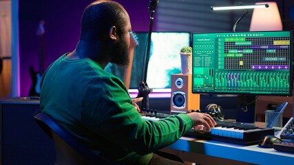 Leinwandbilder - Creative songwriter recording new tracks with microphone and midi controller, playing piano notes in home studio. Skilled musician composing music with electronic keyboard and stereo gear. Camera A.